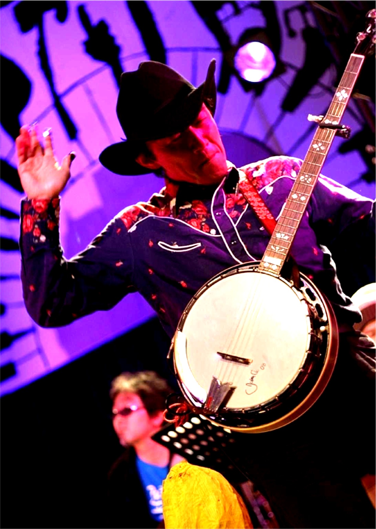 Satoshi Hara playing banjo under stage lights